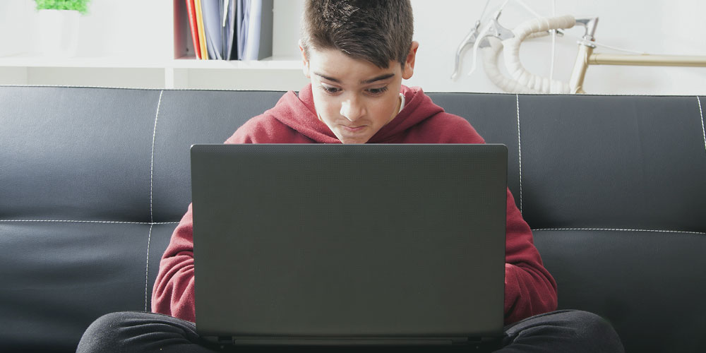 Year 7 and 8 Category - An image of a young, male student working at a laptop. 