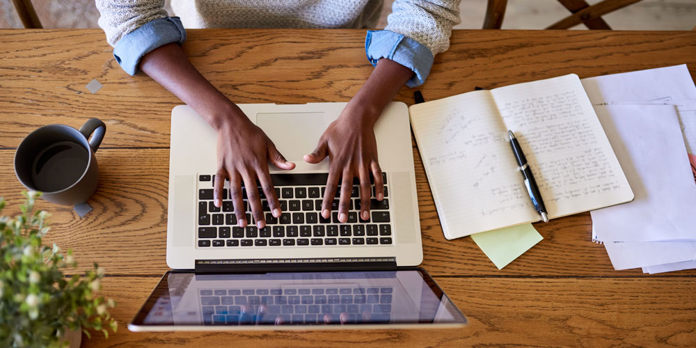 Teachers as Writers Winners 2021 - OVerhead image of a teacher typing on a laptop. 