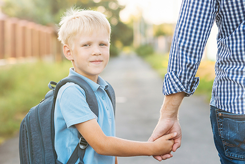 Link: Winner: Plastic Smiles by Charlie Stockings, Canberra High School. Image: A boy on his first day of school, holding his Dad's hand.
